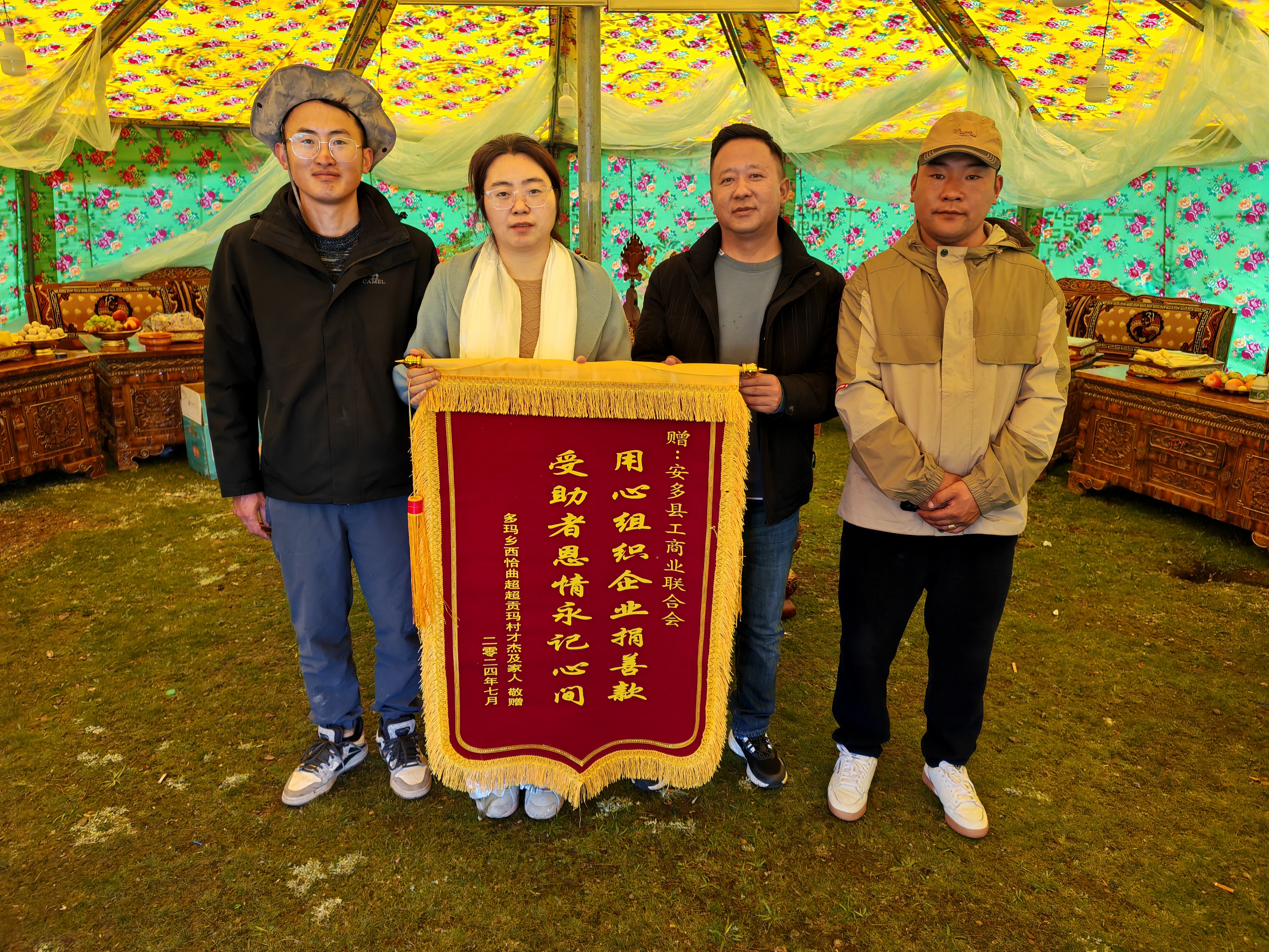 圖為多瑪鄉(xiāng)人大主席多吉次旦（右二）帶領駐村工作隊向縣委統戰(zhàn)部副部長、工商聯主席周利君（左二）敬獻錦旗.jpg