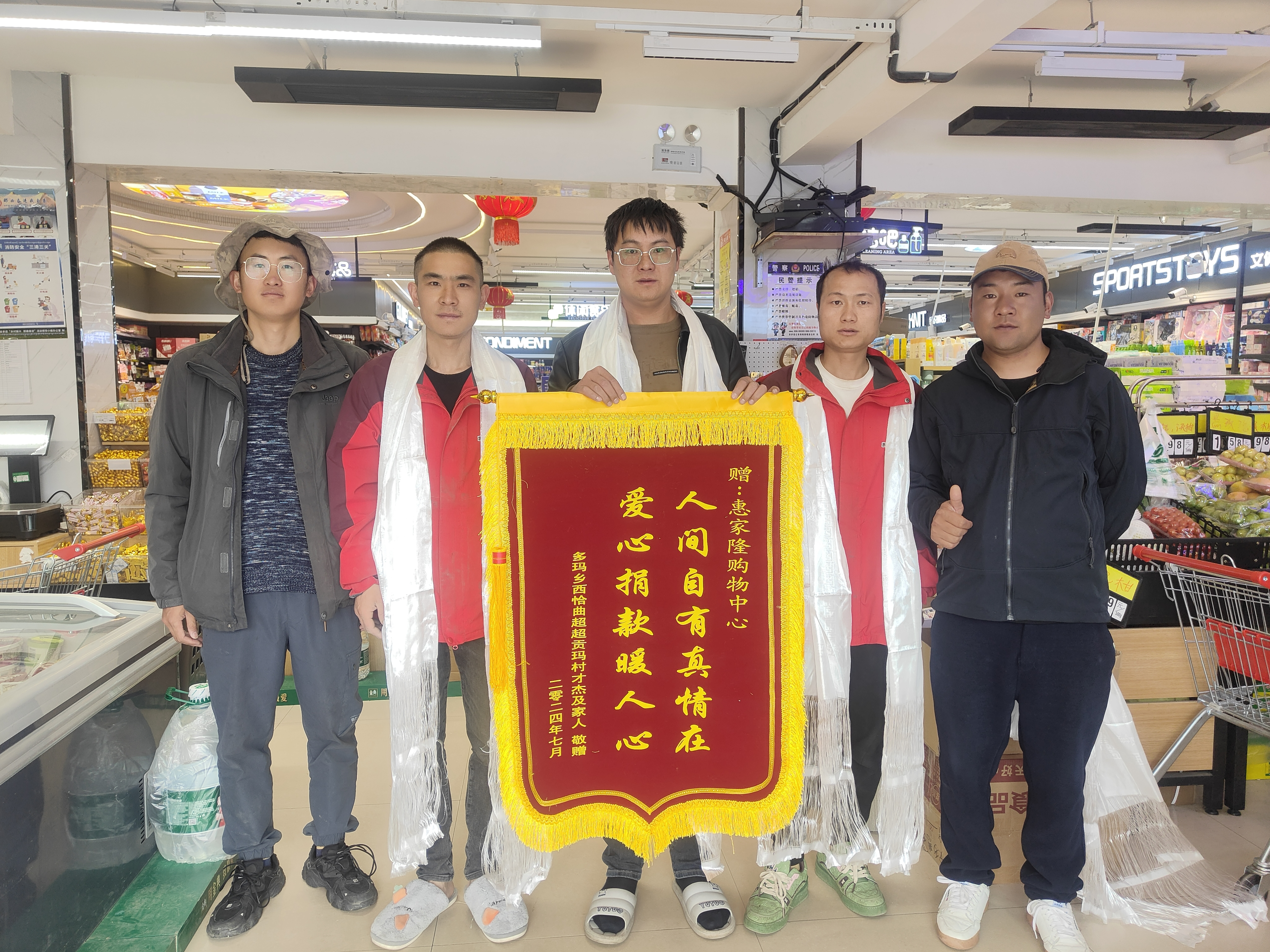圖為駐村工作隊隊長、第一書記王劉恩和駐村工作隊隊員弟古向愛心企業(yè)敬獻錦旗03.jpg