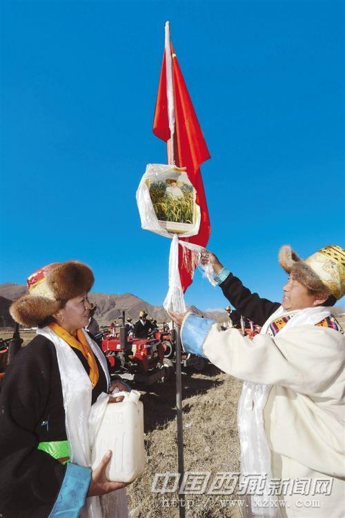 開耕儀式上，桑珠林村村民向領(lǐng)袖像敬獻(xiàn)潔白的哈達(dá)，祝福祖國繁榮昌盛。記者 旦增 攝