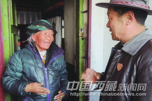 在黨的群眾路線教育實踐活動中，拉薩市城關(guān)區(qū)丹杰林社區(qū)民意組長、66歲的老黨員索朗積極為社區(qū)群眾辦實事，做好事，幫助社區(qū)里的老人與暫住居民解決實際困難，贏得了社區(qū)居民的一致稱贊。 圖為近日索朗在城關(guān)區(qū)丹杰林社區(qū)欽古巷了解卓瑪老人的生活困難。 記者 高加庫 攝