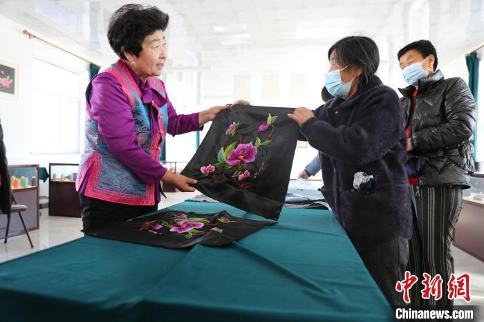 圖為白晶瑩驗收繡工的作品。　科右中旗宣傳部供圖